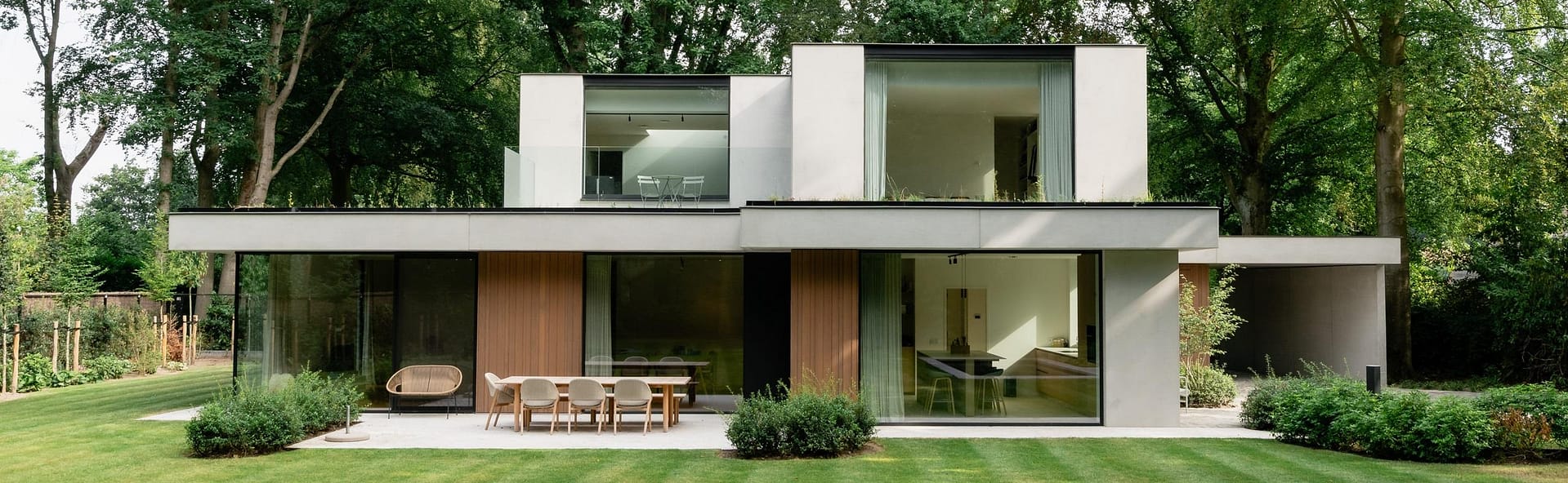 Hedendaagse woning in Brugge, ontworpen door BRES architecten met grote glaspartijen in een groene omgeving